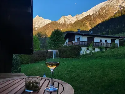 a glass of wine sitting on top of a table at The Mountain View in Les Houches