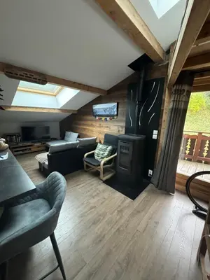 a living room with a couch and a tv at The Mountain View in Les Houches