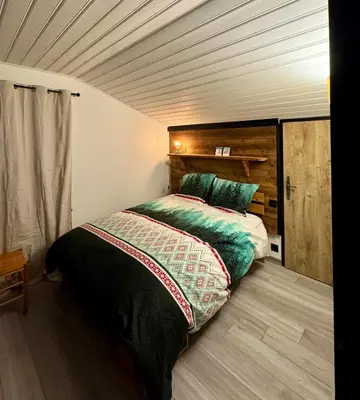 a bedroom with a bed and a wooden ceiling at The Mountain View in Les Houches