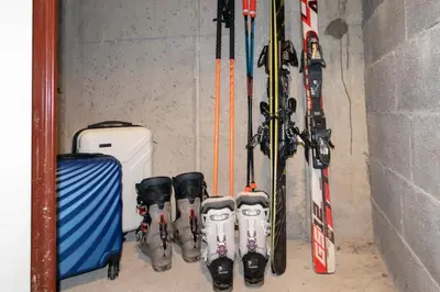 a bunch of skis and poles are lined up against a wall at Au centre du village station de ski in Les Contamines-Montjoie