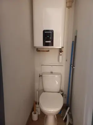 a bathroom with a toilet with a microwave above it at Au centre du village station de ski in Les Contamines-Montjoie
