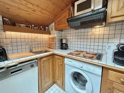 a kitchen with a washing machine and a microwave at Appartement cosy 2P+cabine, 6 couchages, proche télécabine Jaillet et centre, balcon Sud, garage privé - FR-1-597-176 in Megève