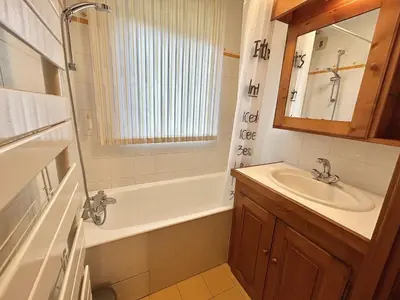 a bathroom with a tub and a sink and a mirror at Appartement cosy 2P+cabine, 6 couchages, proche télécabine Jaillet et centre, balcon Sud, garage privé - FR-1-597-176 in Megève