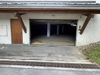 a garage with a door in the side of a building at Appartement cosy 2P+cabine, 6 couchages, proche télécabine Jaillet et centre, balcon Sud, garage privé - FR-1-597-176 in Megève
