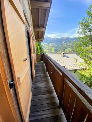 a wooden balcony with a door and a view at Bienvenue dans notre chalet à Saint-Gervais-les-Bains in Saint-Gervais-les-Bains