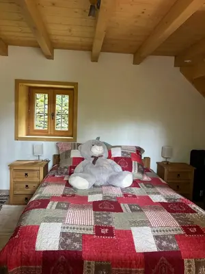 a teddy bear laying on a bed in a bedroom at Bienvenue dans notre chalet à Saint-Gervais-les-Bains in Saint-Gervais-les-Bains