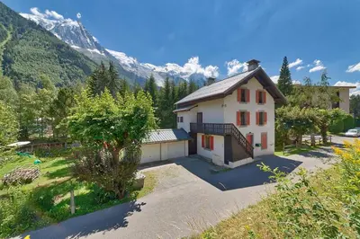 a white house with a mountain in the background at Apartment Serenite in Chamonix-Mont-Blanc