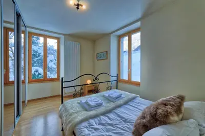 a kitchen with a table and chairs and a clock at Apartment Serenite in Chamonix-Mont-Blanc