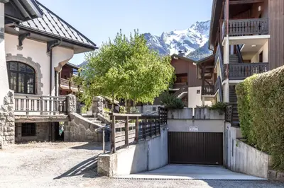 a house with a gate and mountains in the background at Balcon du Mont-Blanc - Calme - Central in Chamonix-Mont-Blanc