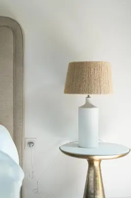 a table with a lamp on it next to a bed at SUNNY MEGEVE - Luxury Flat with services in Megève