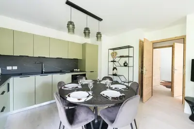 a kitchen and dining room with a table and chairs at SUNNY MEGEVE - Luxury Flat with services in Megève