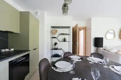 a dining room with a table with plates and wine glasses at SUNNY MEGEVE - Luxury Flat with services in Megève