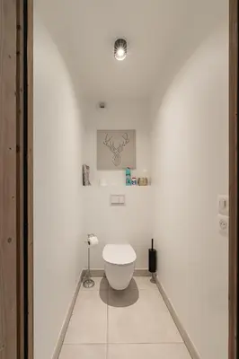a white bathroom with a toilet in the corner at SUNNY MEGEVE - Luxury Flat with services in Megève