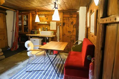 a living room with a table and a red couch at Refuge Margot in Chamonix-Mont-Blanc