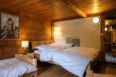 two beds in a room with wooden walls at Refuge Margot in Chamonix-Mont-Blanc