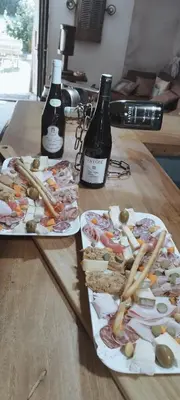 two plates of food and bottles of wine on a table at Bivouac & Sacs à dos - Loft classé, avec escape game sur demande in Sixt