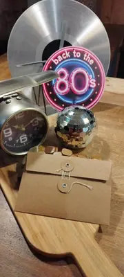 a wooden table with a clock and a sign next to a cd at Bivouac & Sacs à dos - Loft classé, avec escape game sur demande in Sixt