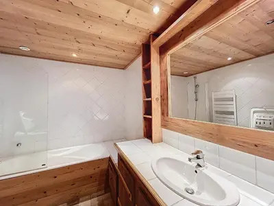 a bathroom with a sink and a tub and a mirror at Appartement 4 pièces avec piscine couverte à Combloux - FR-1-560-127 in Combloux