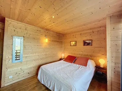 a bedroom with a bed in a wooden cabin at Appartement 4 pièces avec piscine couverte à Combloux - FR-1-560-127 in Combloux