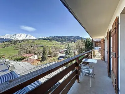 a balcony with a table and chairs and mountains at Appartement 4 pièces avec piscine couverte à Combloux - FR-1-560-127 in Combloux