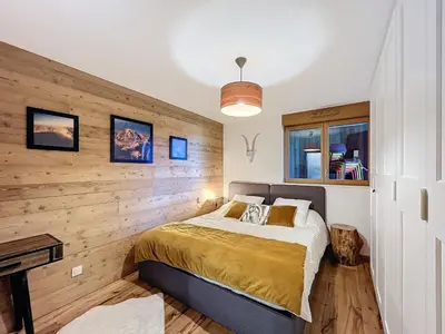 a bedroom with a bed and a wooden wall at Appartement d'Exception 2 Chambres, 63 m², au Pied des Pistes, Parking Inclus, Wi-Fi - FR-1-560-142 in Combloux