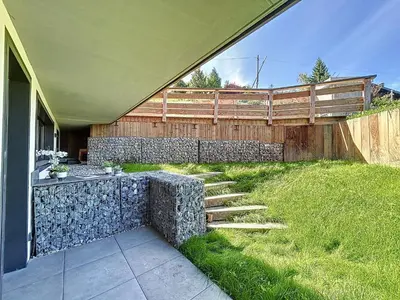a backyard with a stone retaining wall and stairs at Appartement d'Exception 2 Chambres, 63 m², au Pied des Pistes, Parking Inclus, Wi-Fi - FR-1-560-142 in Combloux