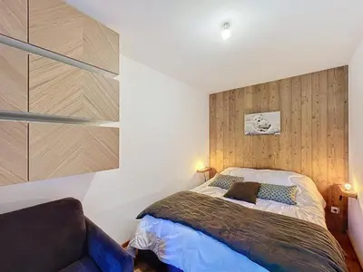 a bedroom with a bed and a couch at Appartement d'Exception 2 Chambres, 63 m², au Pied des Pistes, Parking Inclus, Wi-Fi - FR-1-560-142 in Combloux