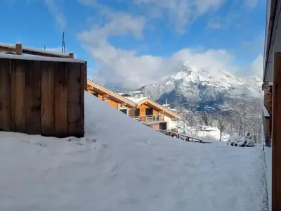 a snow covered hill with a mountain in the background at Appartement d'Exception 2 Chambres, 63 m², au Pied des Pistes, Parking Inclus, Wi-Fi - FR-1-560-142 in Combloux