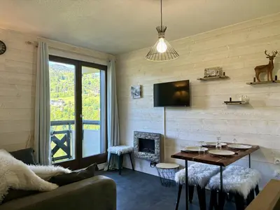 a living room with a table and a fireplace at Mont Lachat - Central - Vues magnifiques in Saint-Gervais-les-Bains
