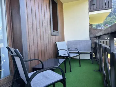 a balcony with chairs and a table and a window at Mont Lachat - Central - Vues magnifiques in Saint-Gervais-les-Bains