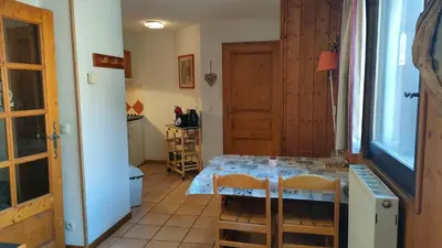 a small kitchen with a table in a room at charmant appartement 2-4 personnes coeur de chamonix in Chamonix-Mont-Blanc