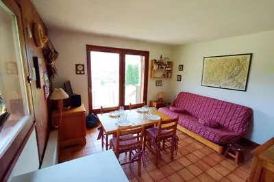 a living room with a table and a red couch at Beautiful apartment near the slopes of Megève in Megève