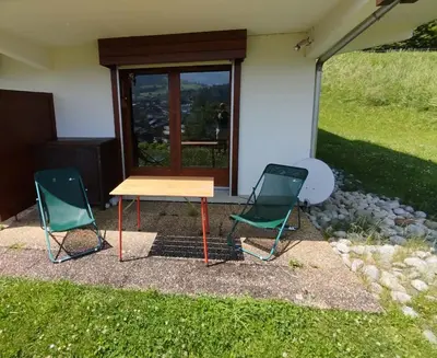 two chairs and a table in front of a house at Beautiful apartment near the slopes of Megève in Megève