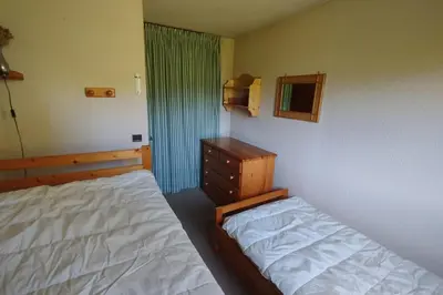 a bedroom with a bed and a dresser and a window at Beautiful apartment near the slopes of Megève in Megève