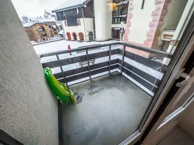 a view of a balcony from a window with a green swing at Appartement en pied de piste dans résidence en haute Savoie in Morillon