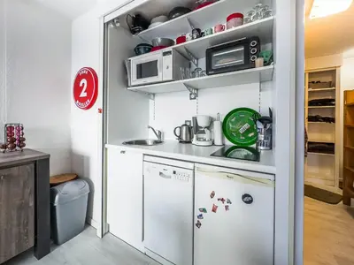 a small kitchen with a refrigerator and a microwave at Appartement en pied de piste dans résidence en haute Savoie in Morillon