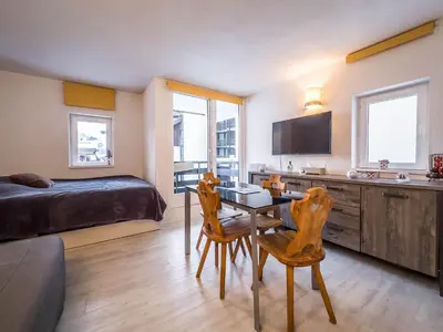 a bedroom with a bed and a table and chairs at Appartement en pied de piste dans résidence en haute Savoie in Morillon