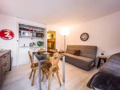 a living room with a table and a couch at Appartement en pied de piste dans résidence en haute Savoie in Morillon