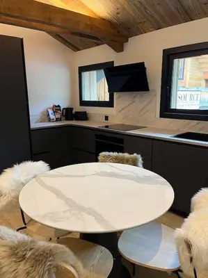 a kitchen with a white table and some chairs at Appartement cosy rénové in Megève