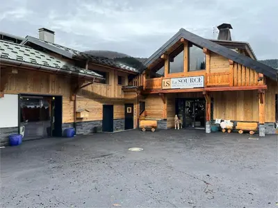 a large wooden building with a sign that reads us ranch hotel at Appartement cosy rénové in Megève
