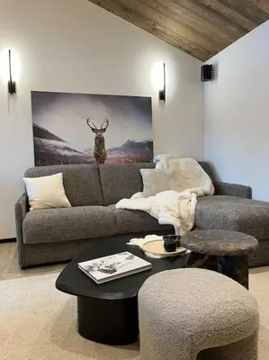 a living room with a couch and a table at Appartement cosy rénové in Megève
