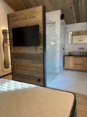 a living room with a television and a large room at Appartement cosy rénové in Megève