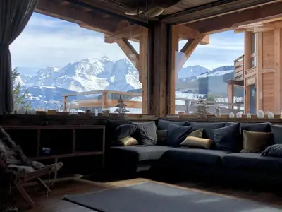 a couch in a room with a view of a mountain at Appartement Luxe comme un Chalet - vue exceptionnelle in Combloux