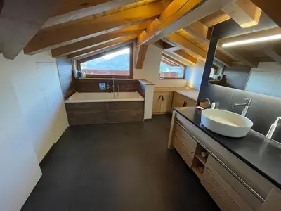 a bathroom with a tub and a sink and a bath tub at Appartement Luxe comme un Chalet - vue exceptionnelle in Combloux