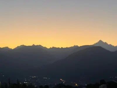 a view of mountains at sunset with the sun setting at Appartement Luxe comme un Chalet - vue exceptionnelle in Combloux