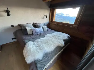 a bed in a room with a window at Appartement Luxe comme un Chalet - vue exceptionnelle in Combloux