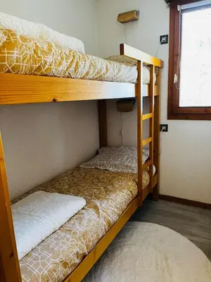 two bunk beds in a room with a window at Appartement Calme et Chaleureux in Demi-Quartier