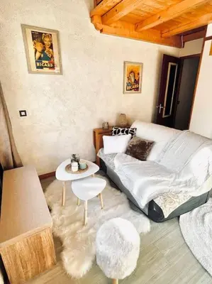 a living room with a bed and a table at Appartement Calme et Chaleureux in Demi-Quartier
