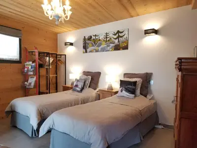 a bedroom with two beds and a chandelier at Chalet Walser à VALLORCINE 13 kms CHAMONIX France in Vallorcine