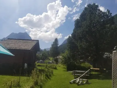a field with a barn and mountains in the background at Chalet Walser à VALLORCINE 13 kms CHAMONIX France in Vallorcine